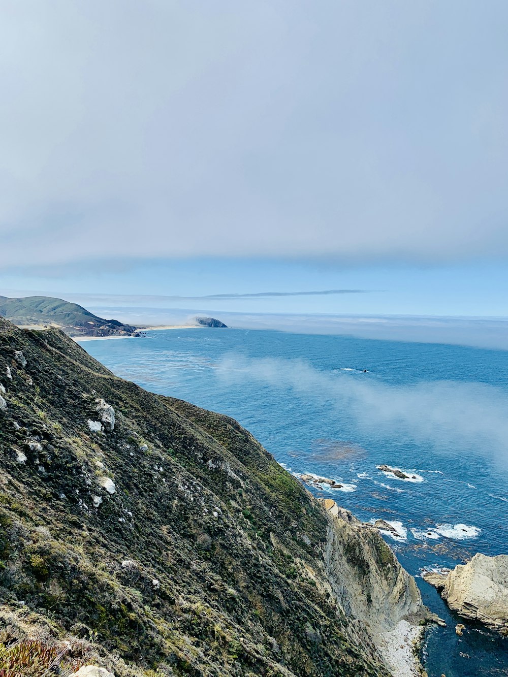 a view of the ocean from the top of a hill