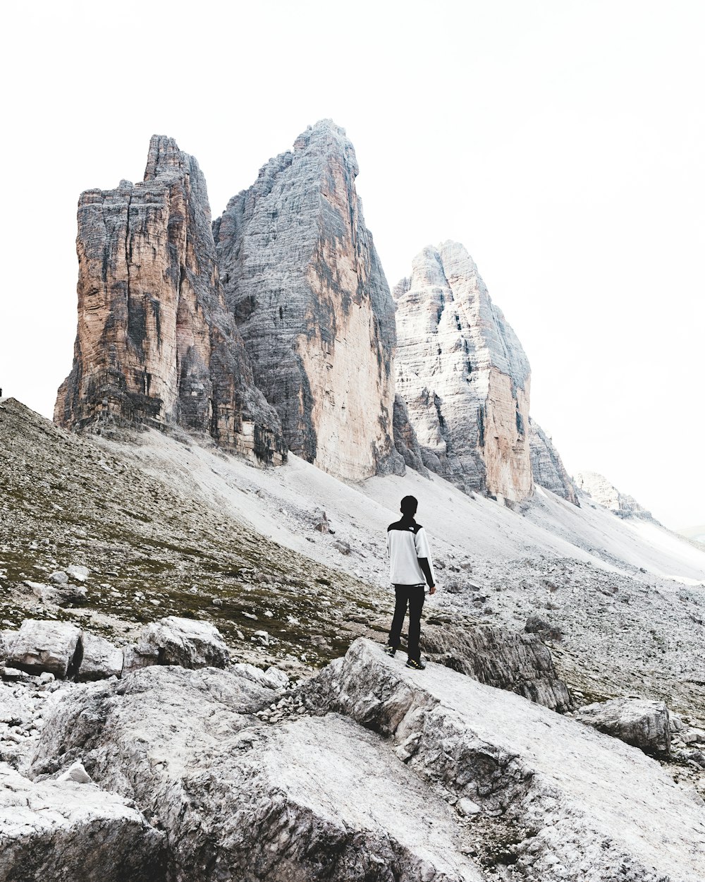 Una persona parada en la cima de una montaña cubierta de nieve