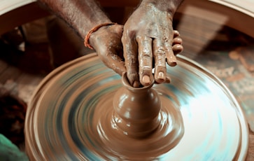 a person making a vase on a potter's wheel