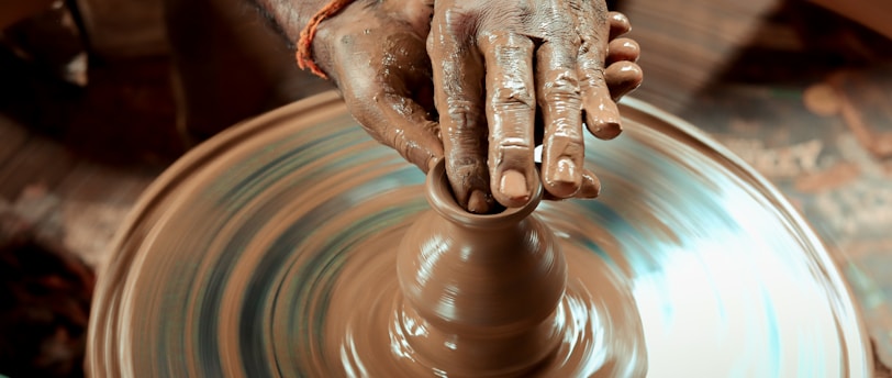 a person making a vase on a potter's wheel