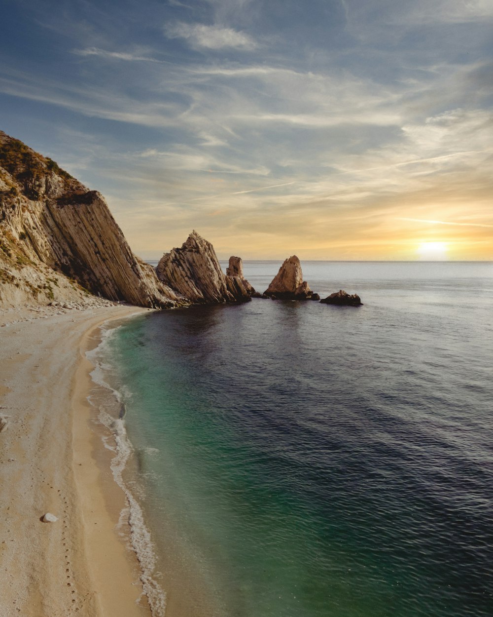 una playa de arena junto a una gran masa de agua