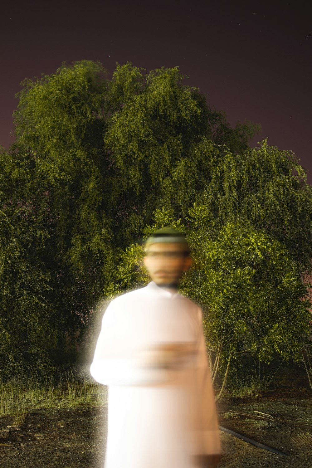 a blurry photo of a man walking in front of a tree