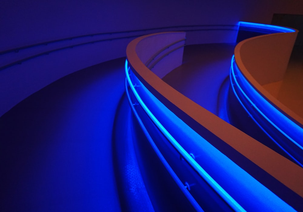 a curved wall with blue lights in a room