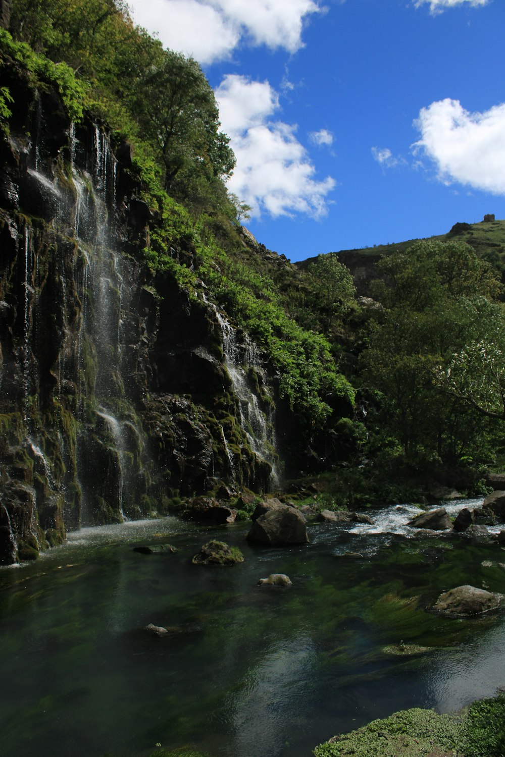 a small waterfall in the middle of a forest