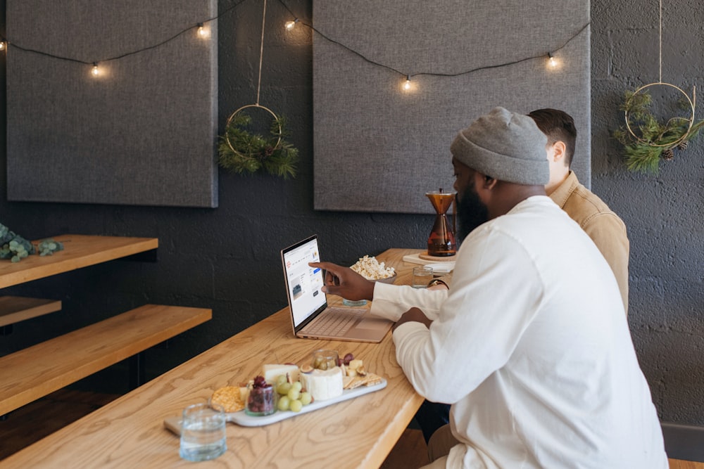 Deux personnes collaborant sur leur ordinateur portable Surface assises sur une table au travail 