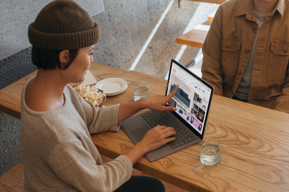 Two people sitting across from each other in an office working on a Surface laptop