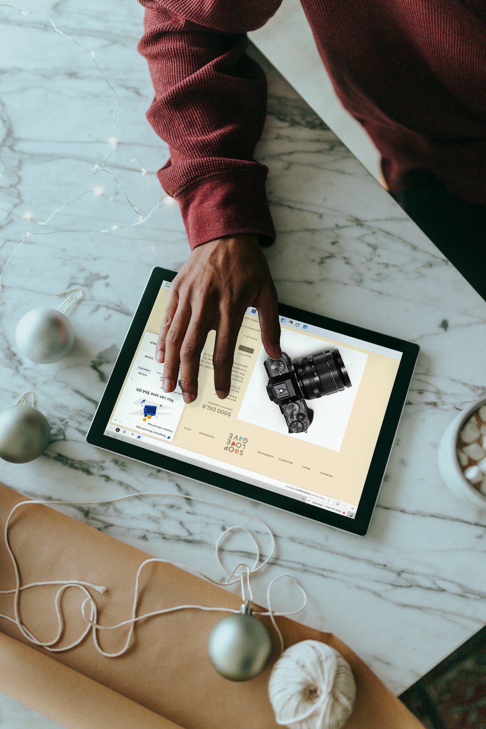 Overhead view of a person clicking on a Surface laptop with wrapping presents around