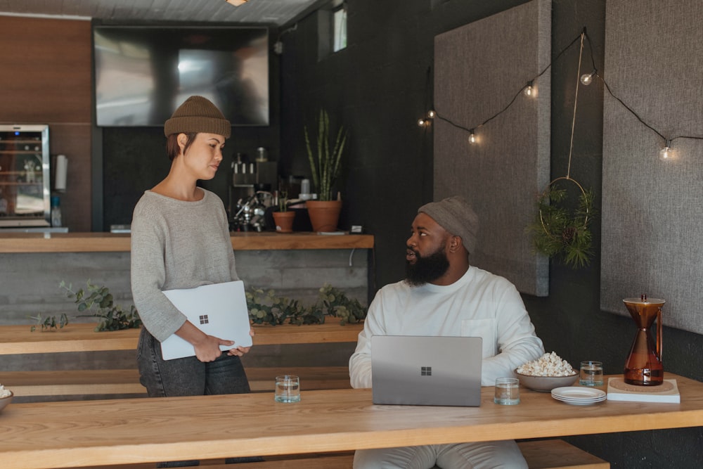 Two coworkers talking at work holding Surface laptops