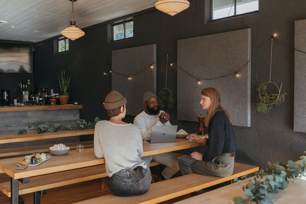 Three co-workers sitting together in the office with Surface laptop on the table