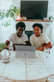 Two people smiling while looking at their Surface laptop 