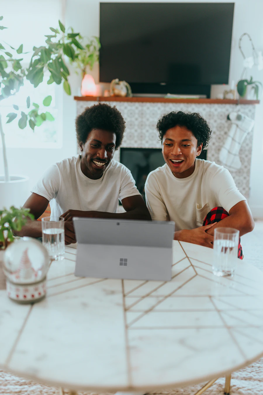 Two people smiling as they look at a laptop together