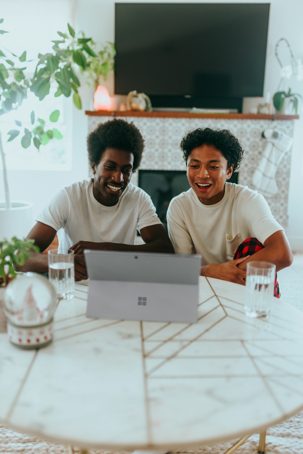 Two people smiling while looking at their Surface laptop 