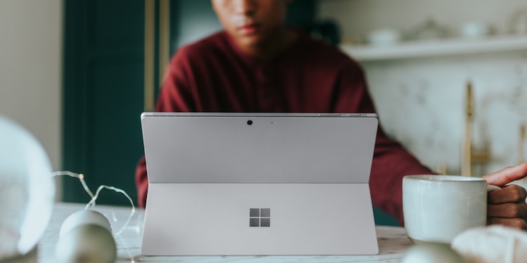 Man on his Surface laptop at home with Christmas decorations around