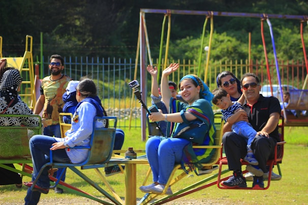A group of kids excitedly riding a funfair carousel with big smiles