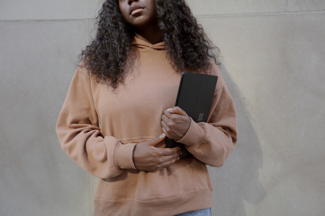 Female holding her Surface laptop with a wall in the background