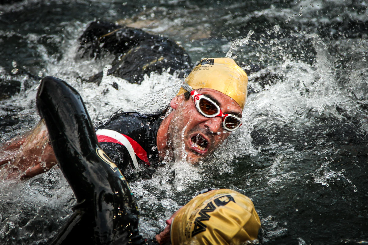 Schwimmer mit gelber Badekappe im offenen Wasser