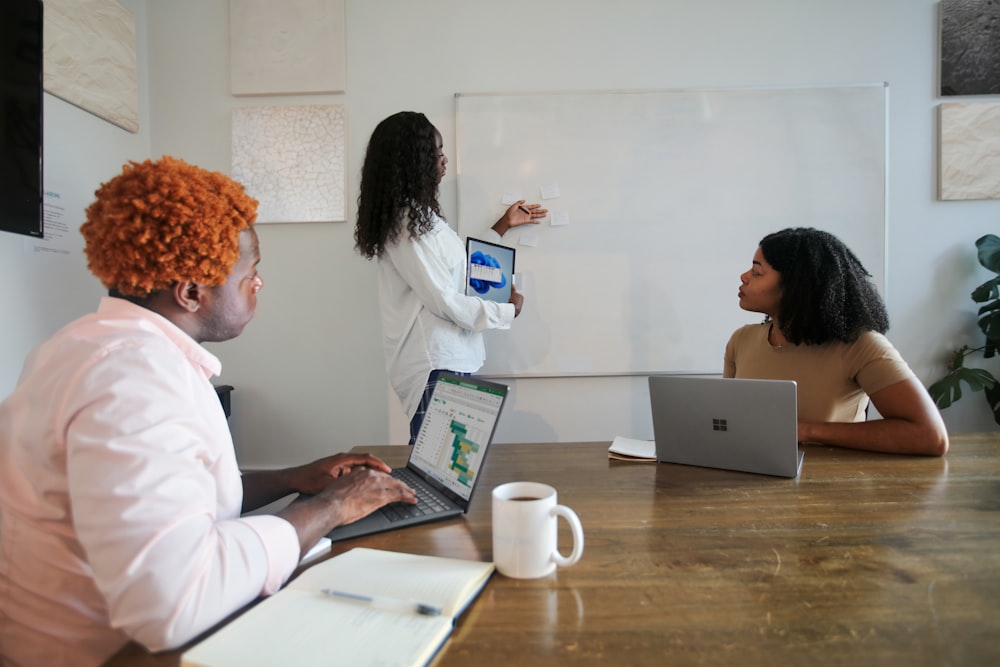 Three people in an office working with their Microsoft laptops 