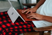 Person in checkered pajamas on their Surface laptop at home