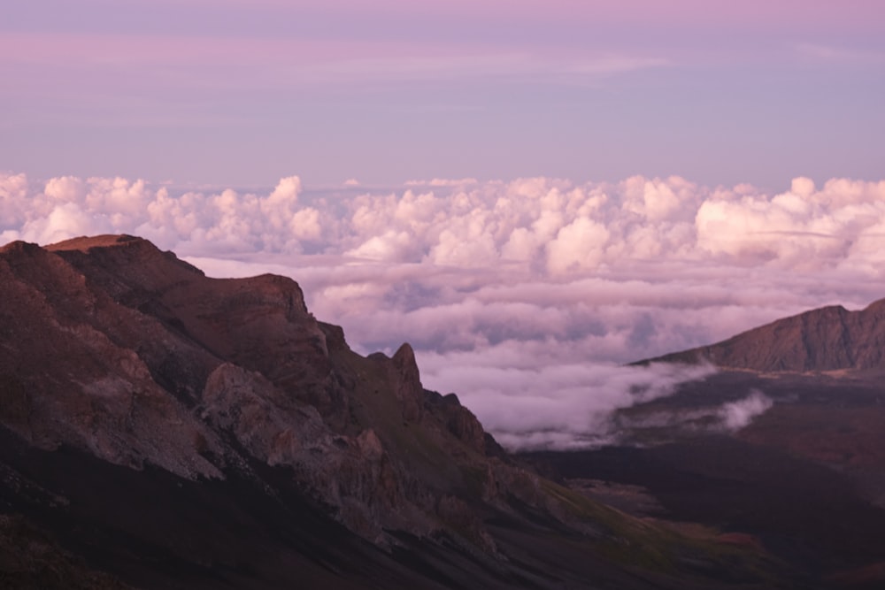 a view of the mountains and clouds from the top of a mountain