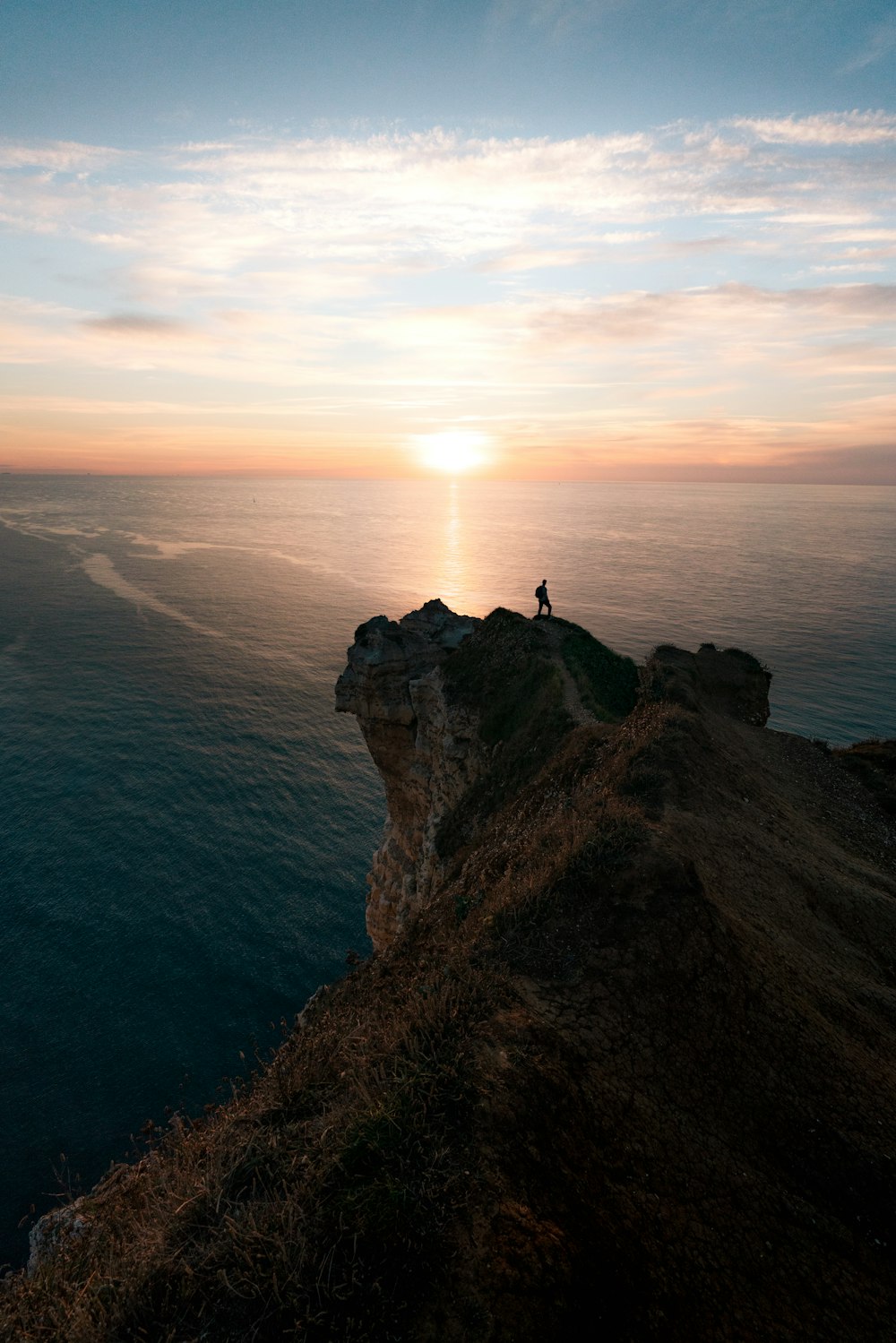 a person standing on top of a cliff overlooking the ocean