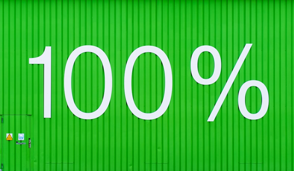una pared verde con un letrero blanco que dice 100%