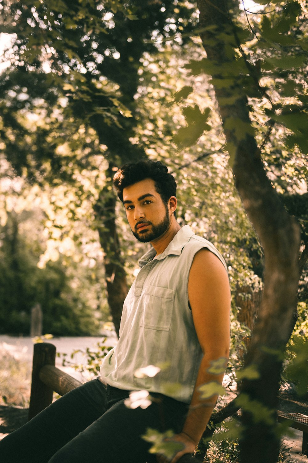 a man sitting on a bench in the woods