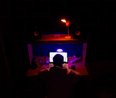 A focused writer working on AI news articles in a cozy home office filled with tech gadgets.