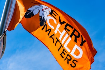 a very large orange flag flying in the sky