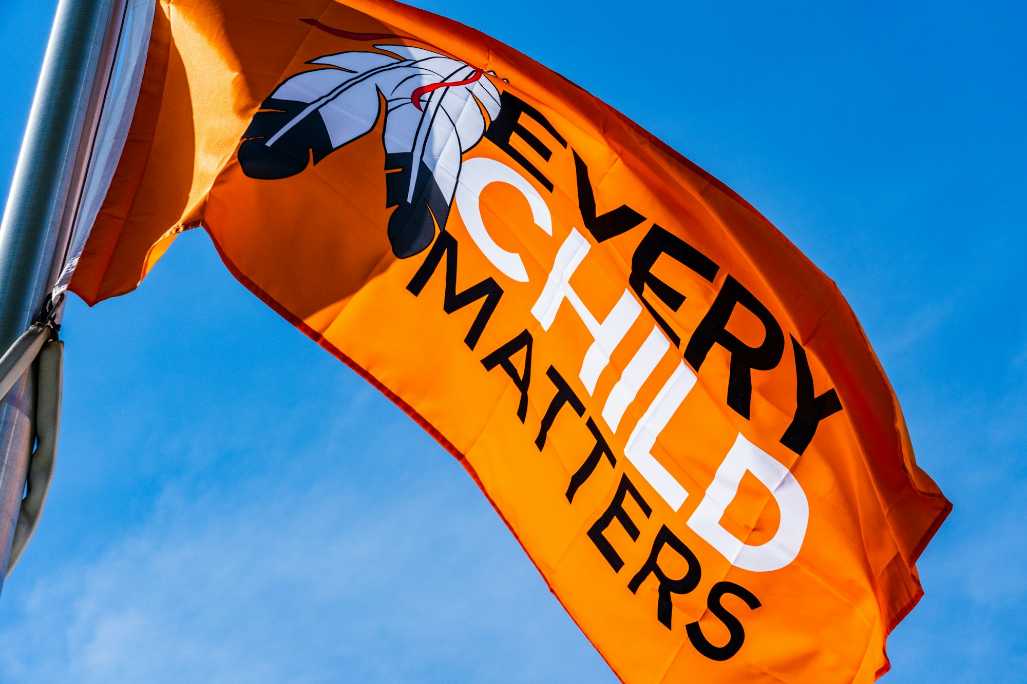 a very large orange flag flying in the sky