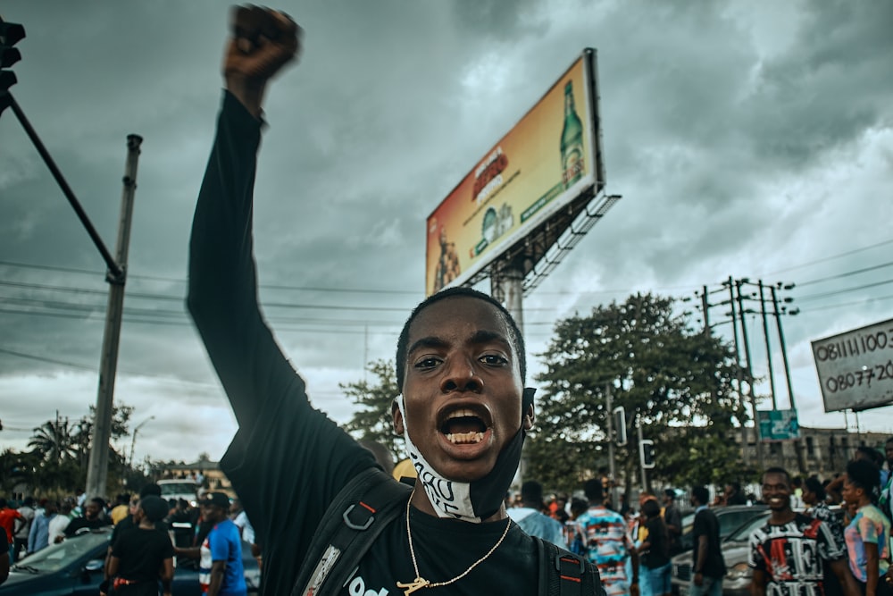 a man holding up a sign in front of a crowd