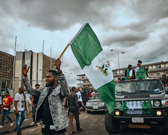 a group of people walking down a street holding a flag