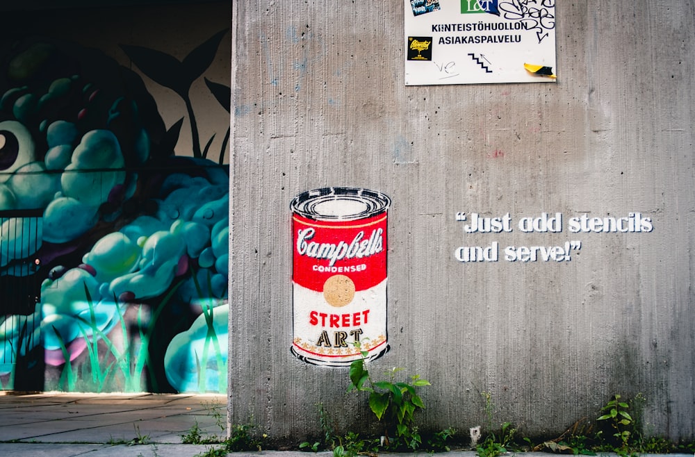 a wall with graffiti and a can of street art on it