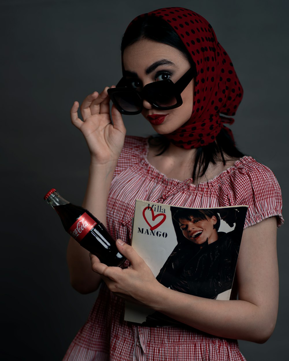a woman in a red dress holding a bottle of wine