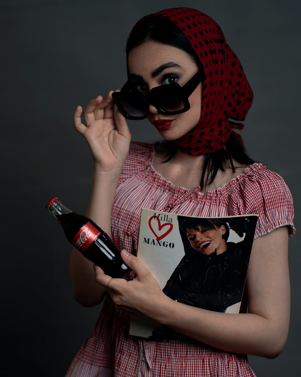 Une femme en robe rouge tenant une bouteille de vin