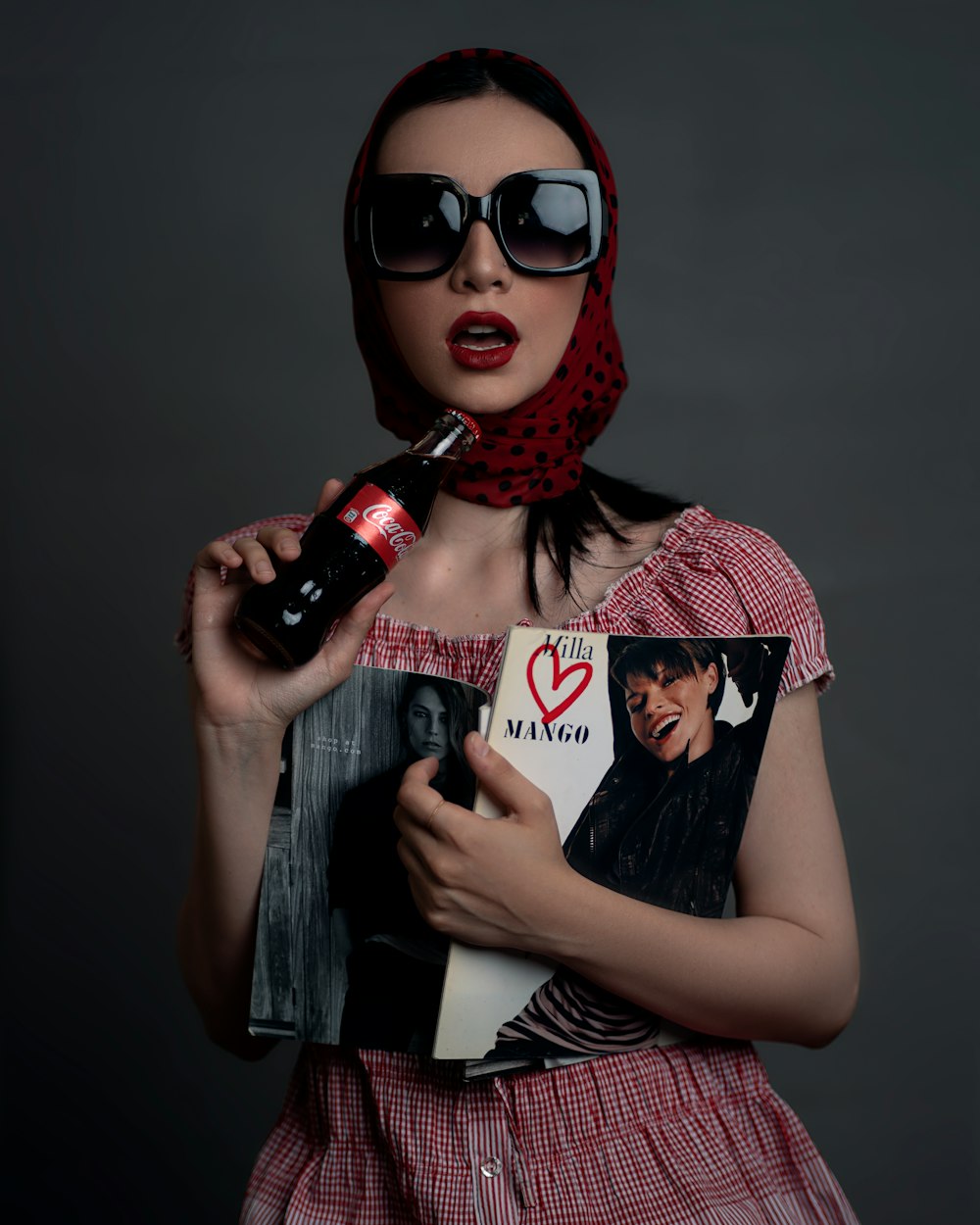 a woman in a red dress holding a book and a microphone