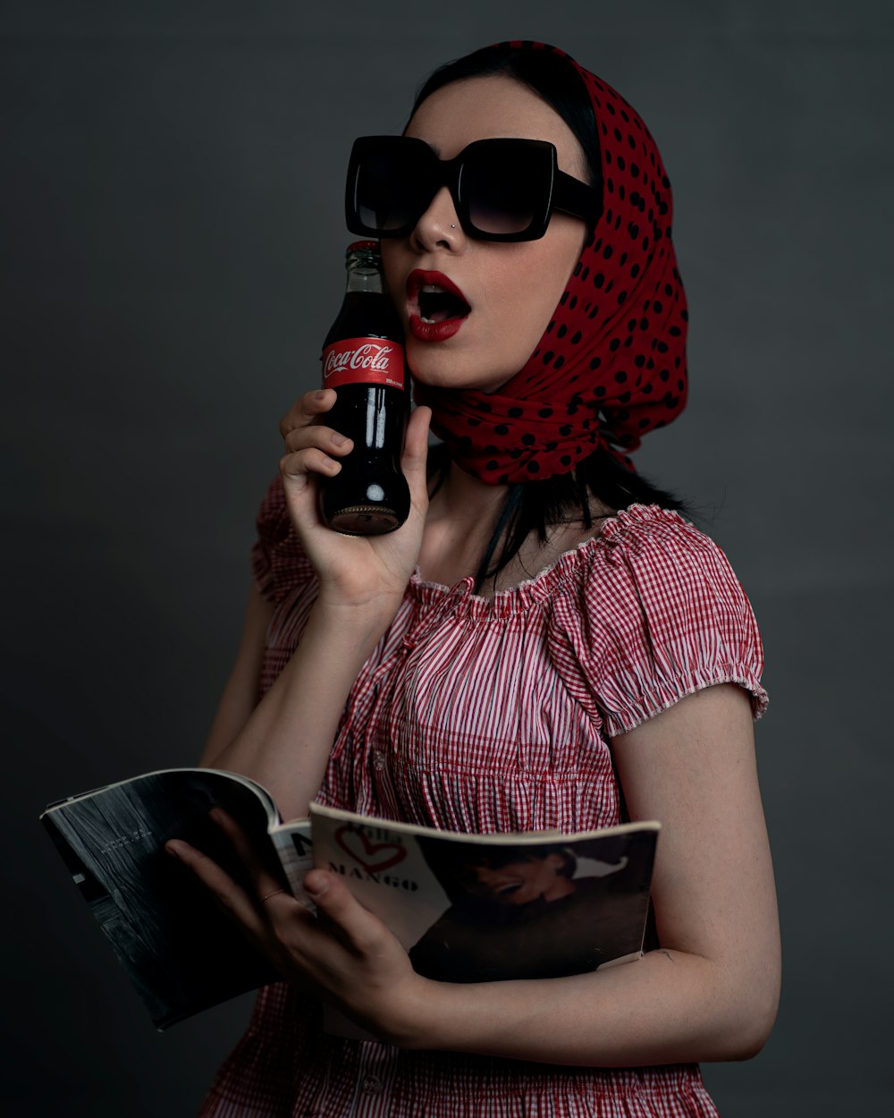 a woman in a red dress holding a bottle of beer