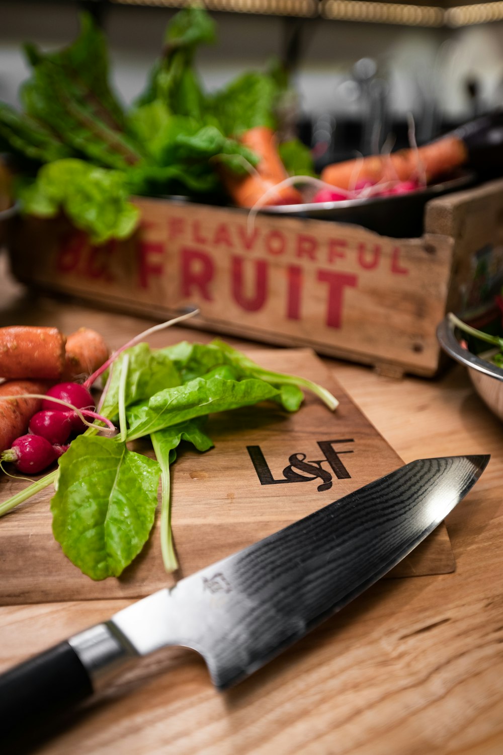 a cutting board with carrots and spinach on it