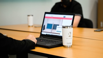 a laptop computer sitting on top of a wooden table