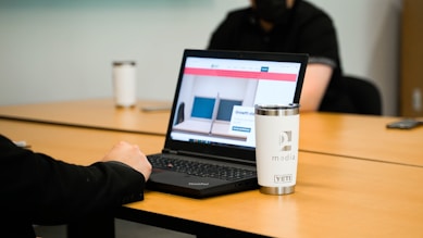 a laptop computer sitting on top of a wooden table