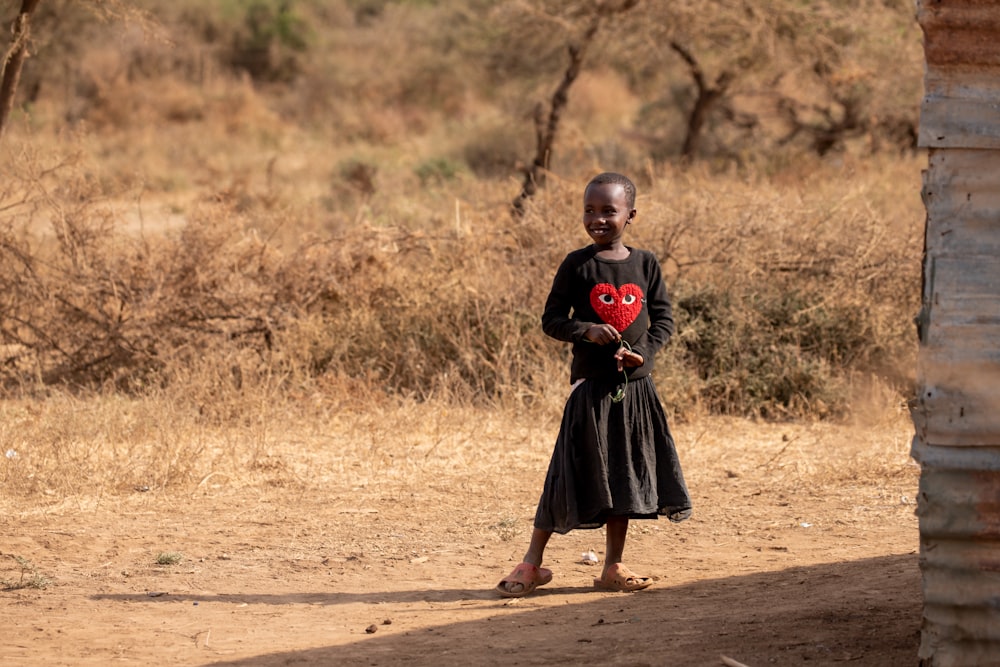 a young girl holding a red heart in her hands