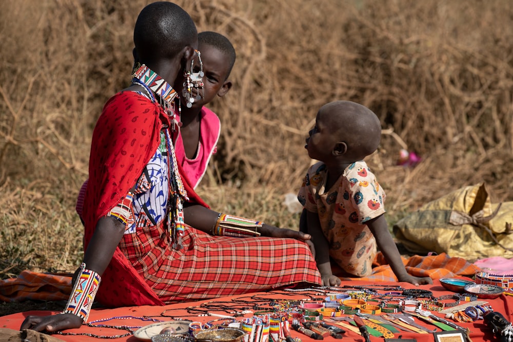 a couple of women sitting on top of a blanket