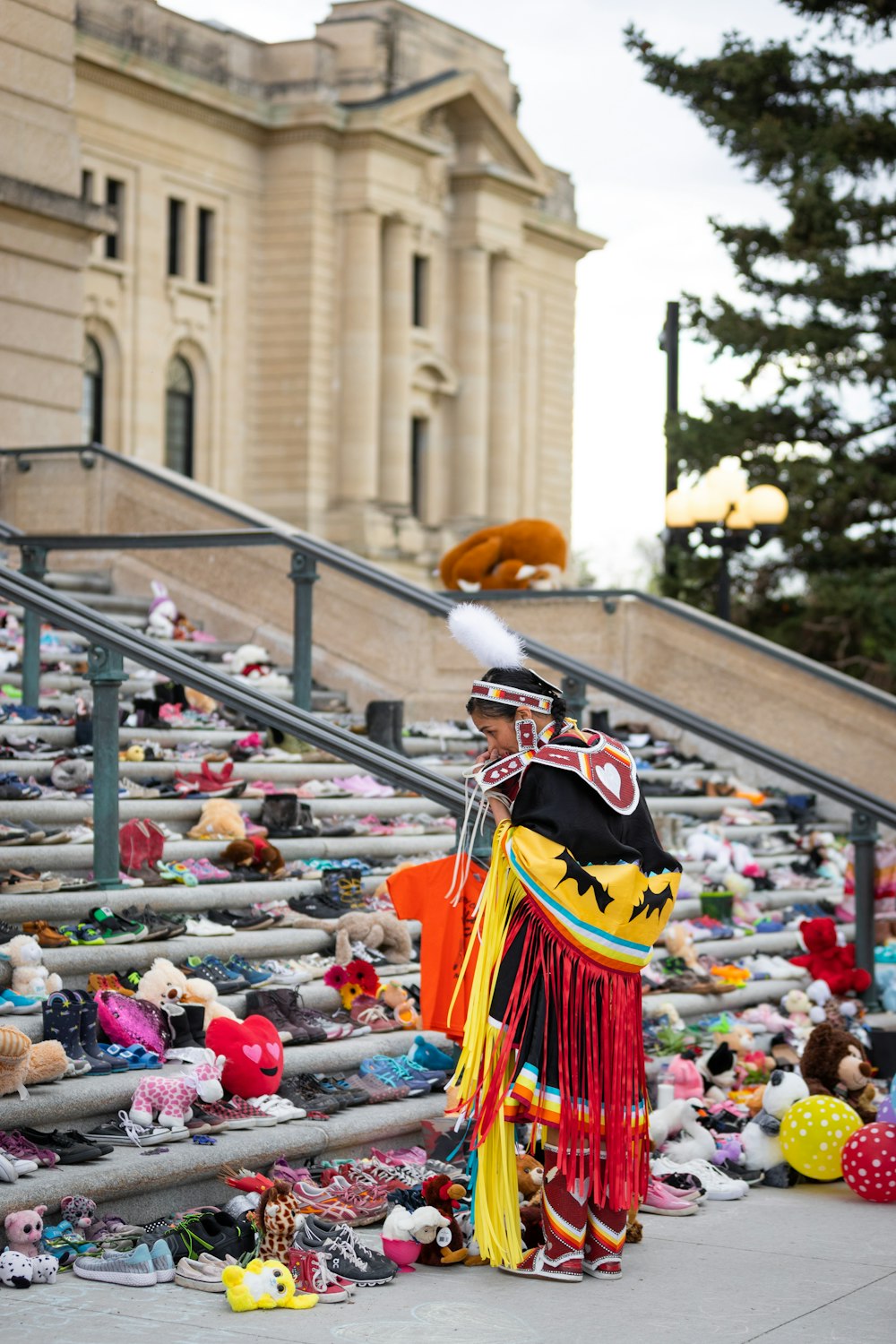 a man dressed in a costume standing next to a bunch of stuffed animals