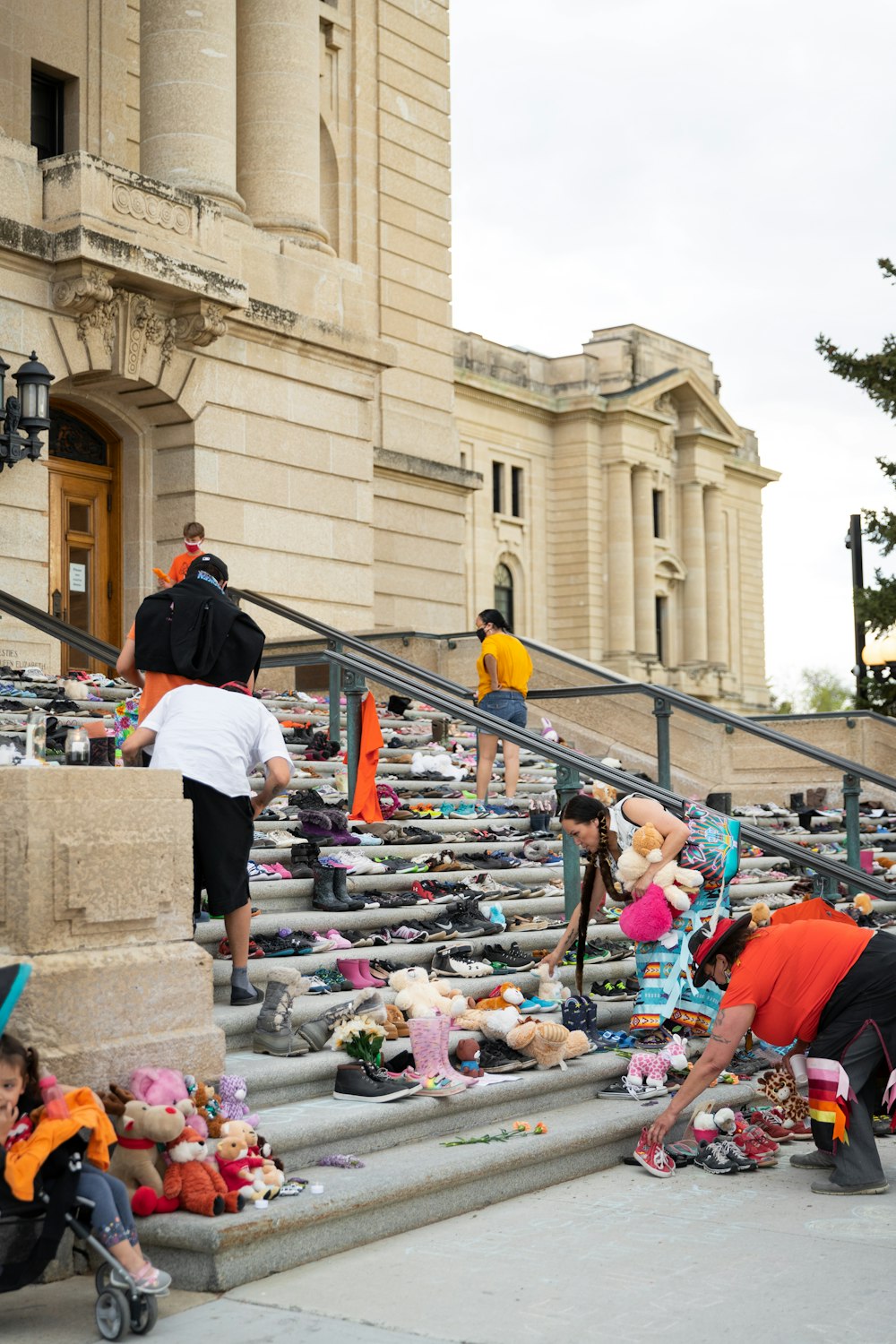 a group of people with stuffed animals on the steps of a building