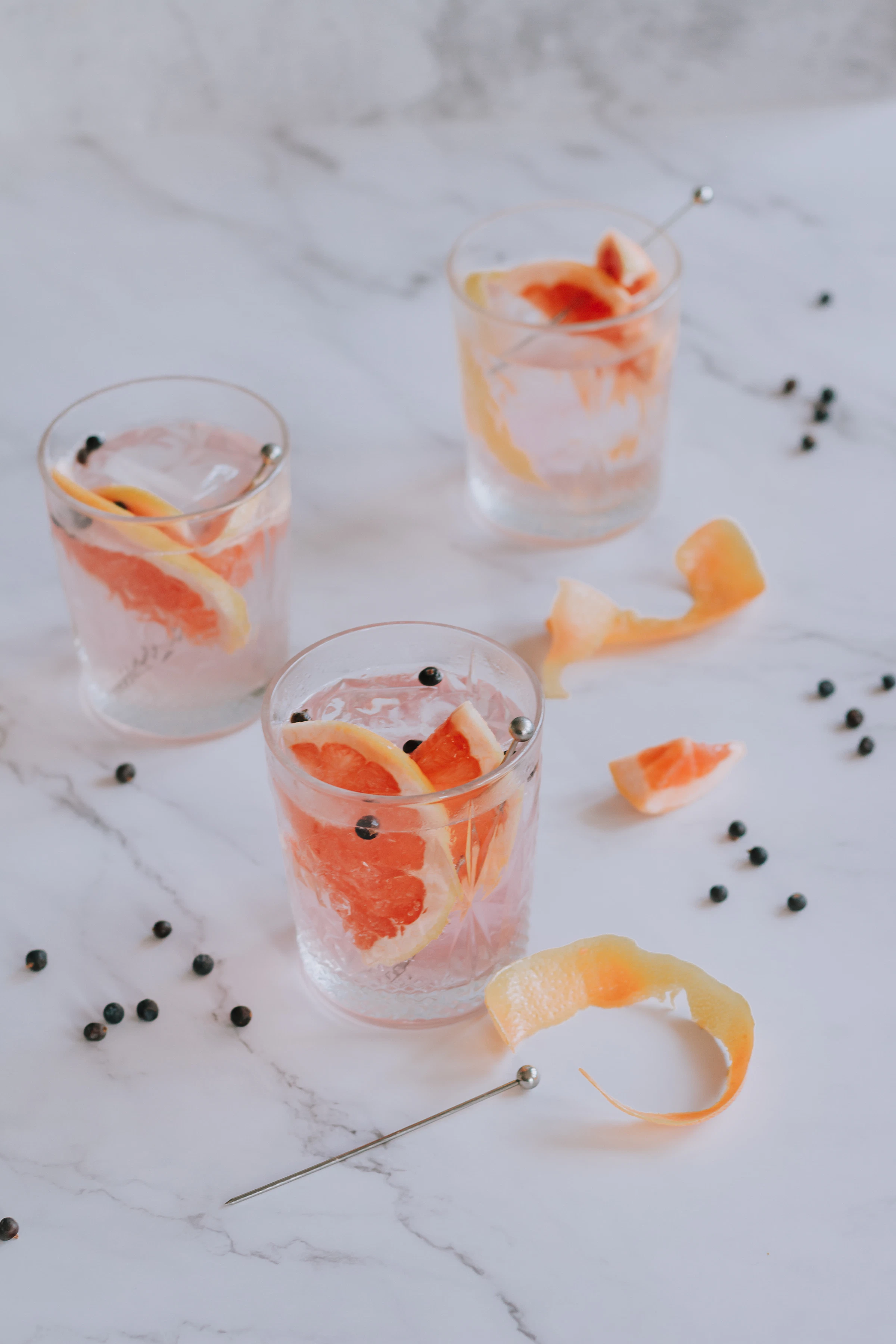 Grapefruit and juniper gin and tonic glasses on a table