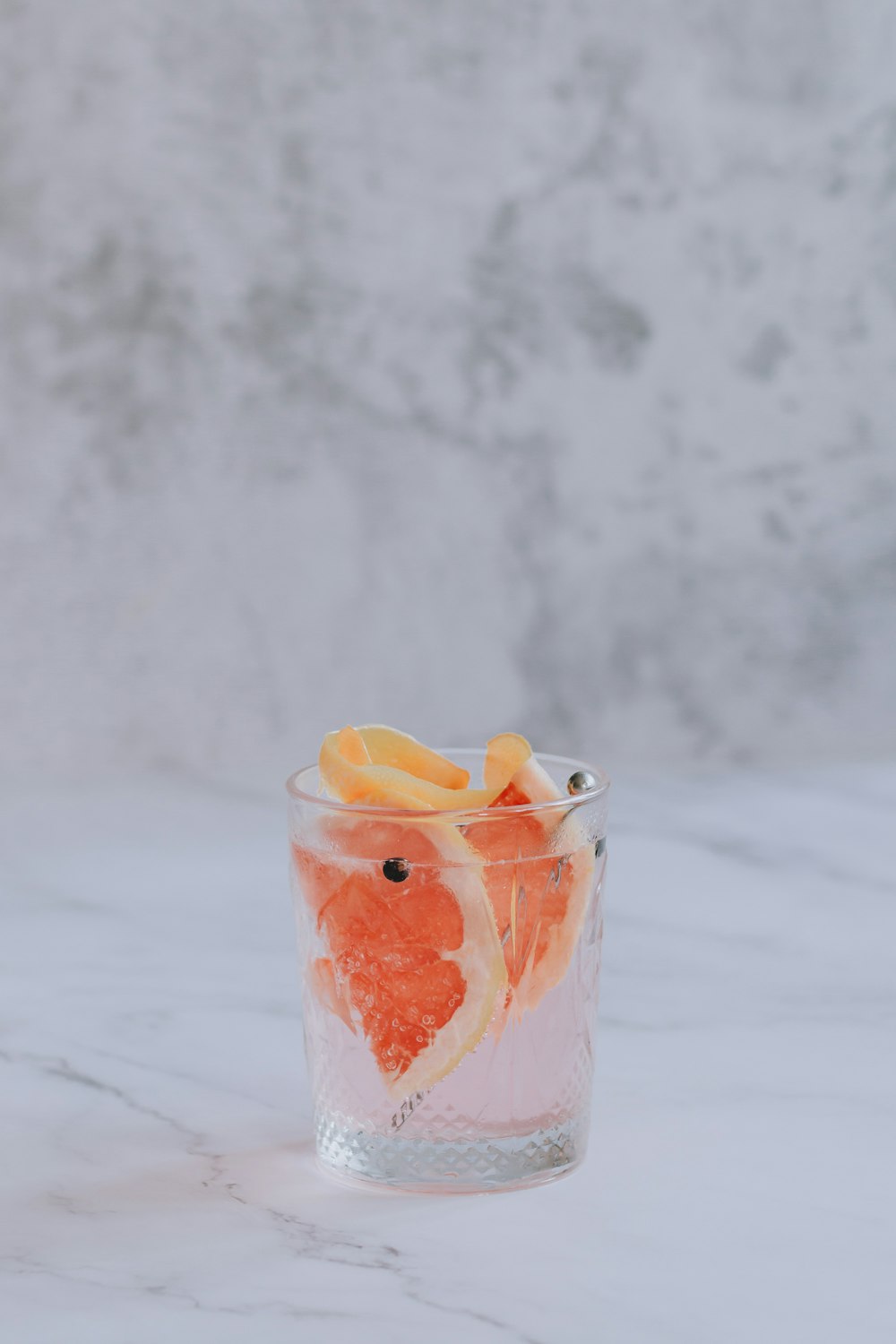 a glass filled with orange slices and water