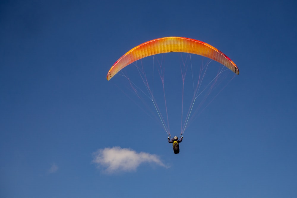 a person is parasailing in the blue sky