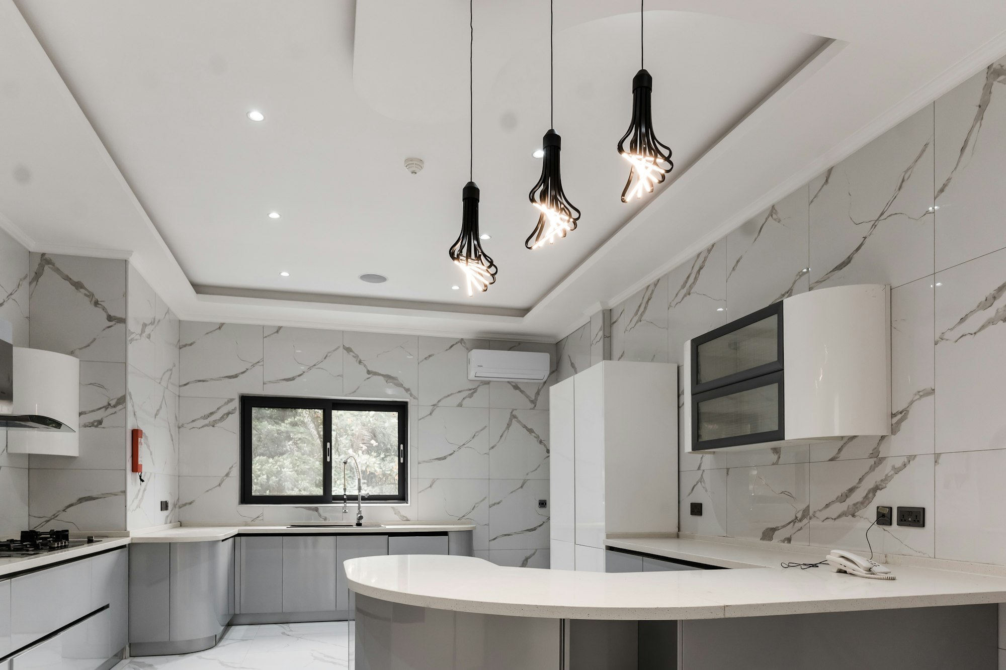 A kitchen with multiple light bulbs and chandeliers