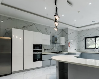 a modern kitchen with marble counter tops and stainless steel appliances