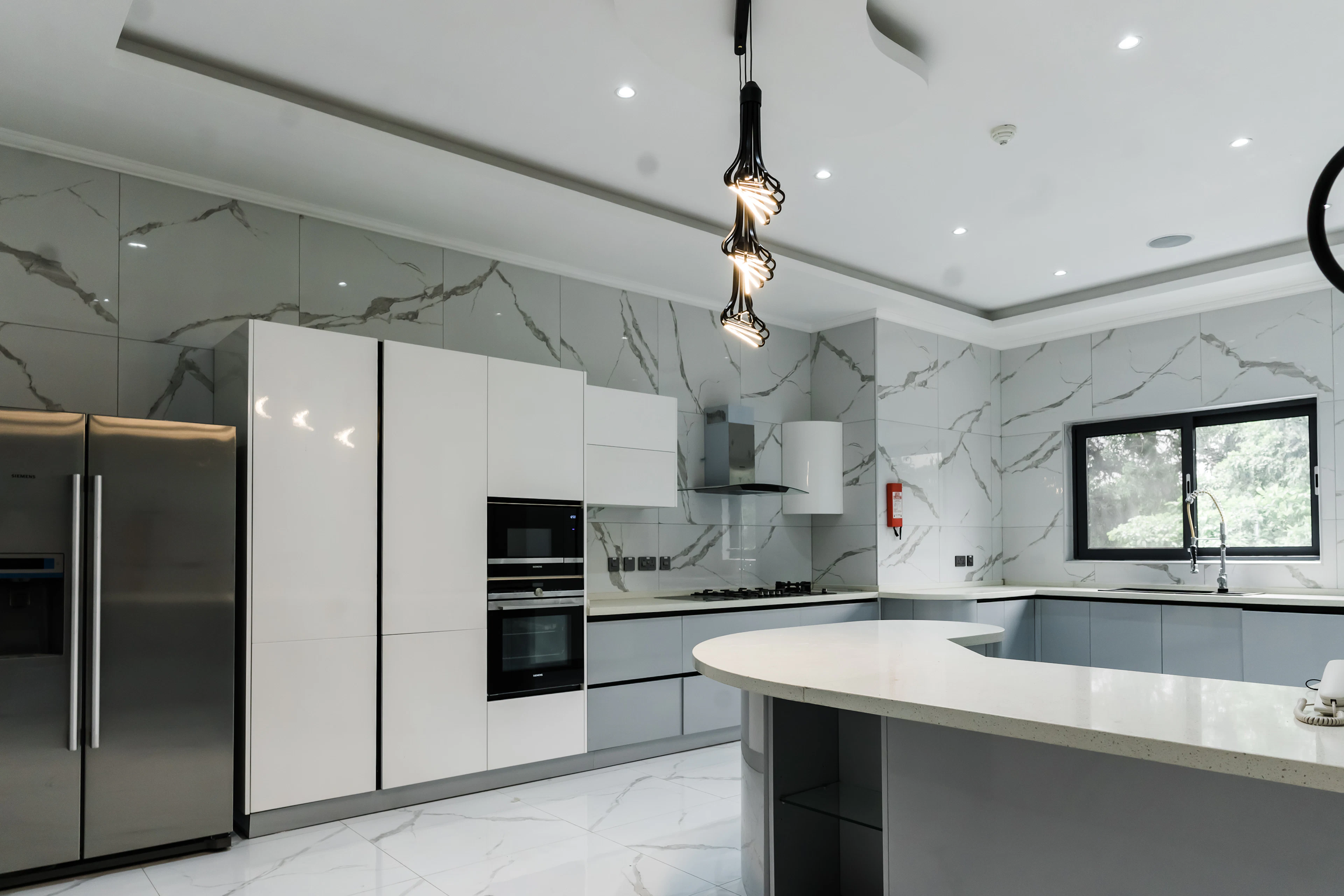 Open kitchen with a marble island and built-in appliances