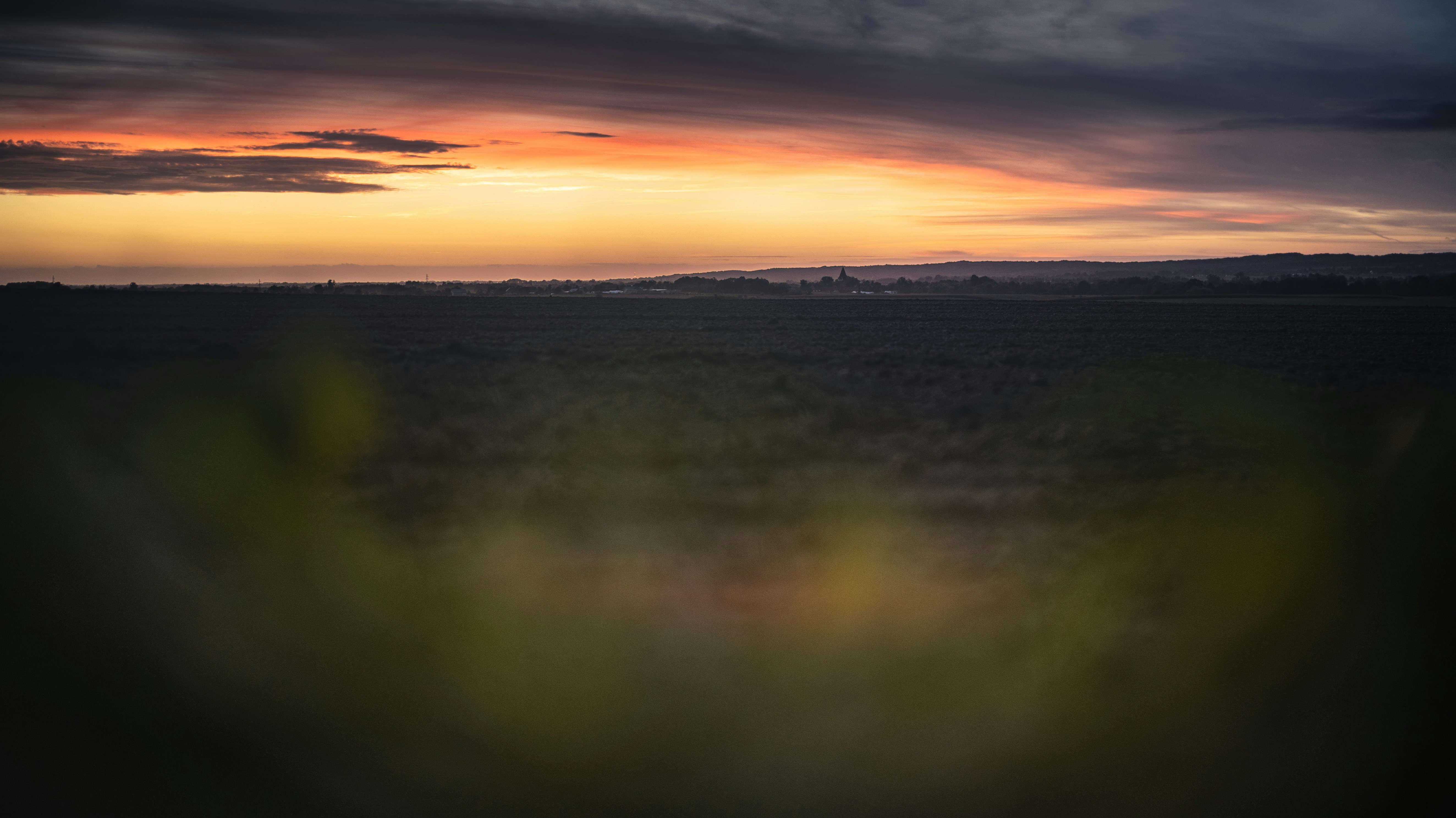 the sun is setting over a field of grass, Polish village.